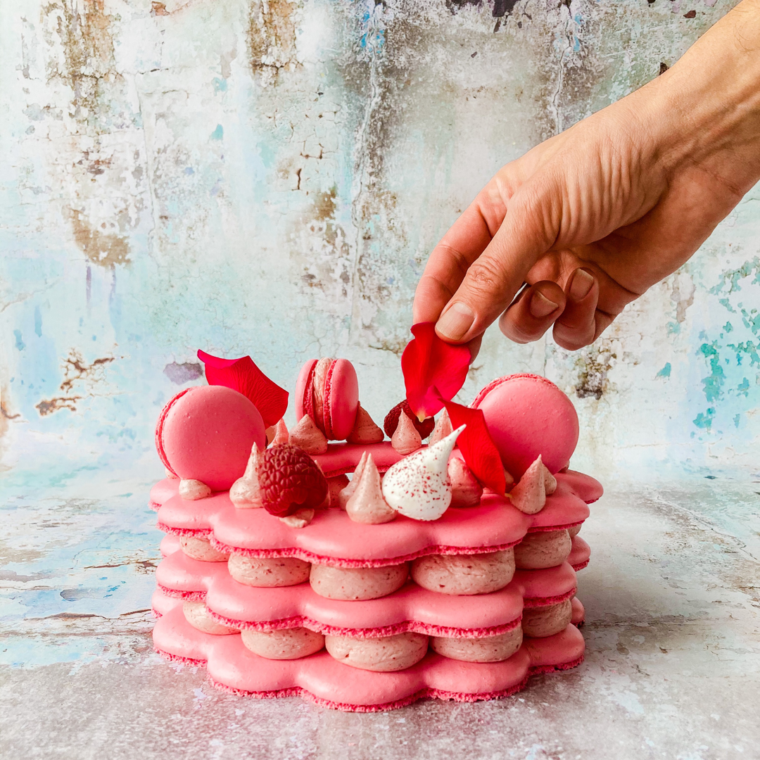 Raspberry & Rose Macaron Stack Cake with  pink mini macarons, fresh raspberries, meringue kisses and rose petals